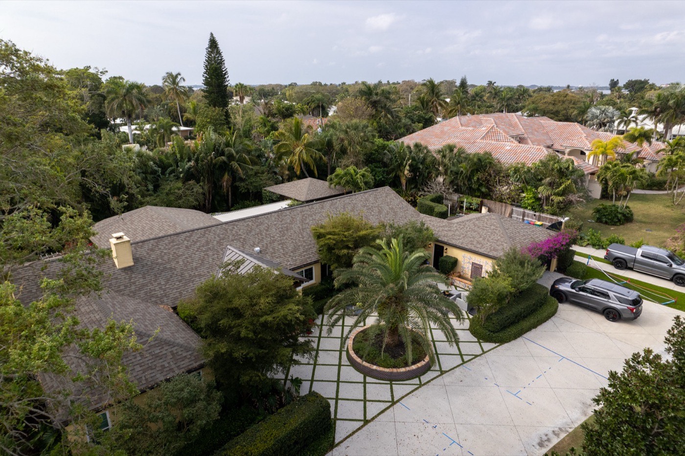 Aerial of a diamond-pattern hardscape courtyard with a canary date palm centerpiece