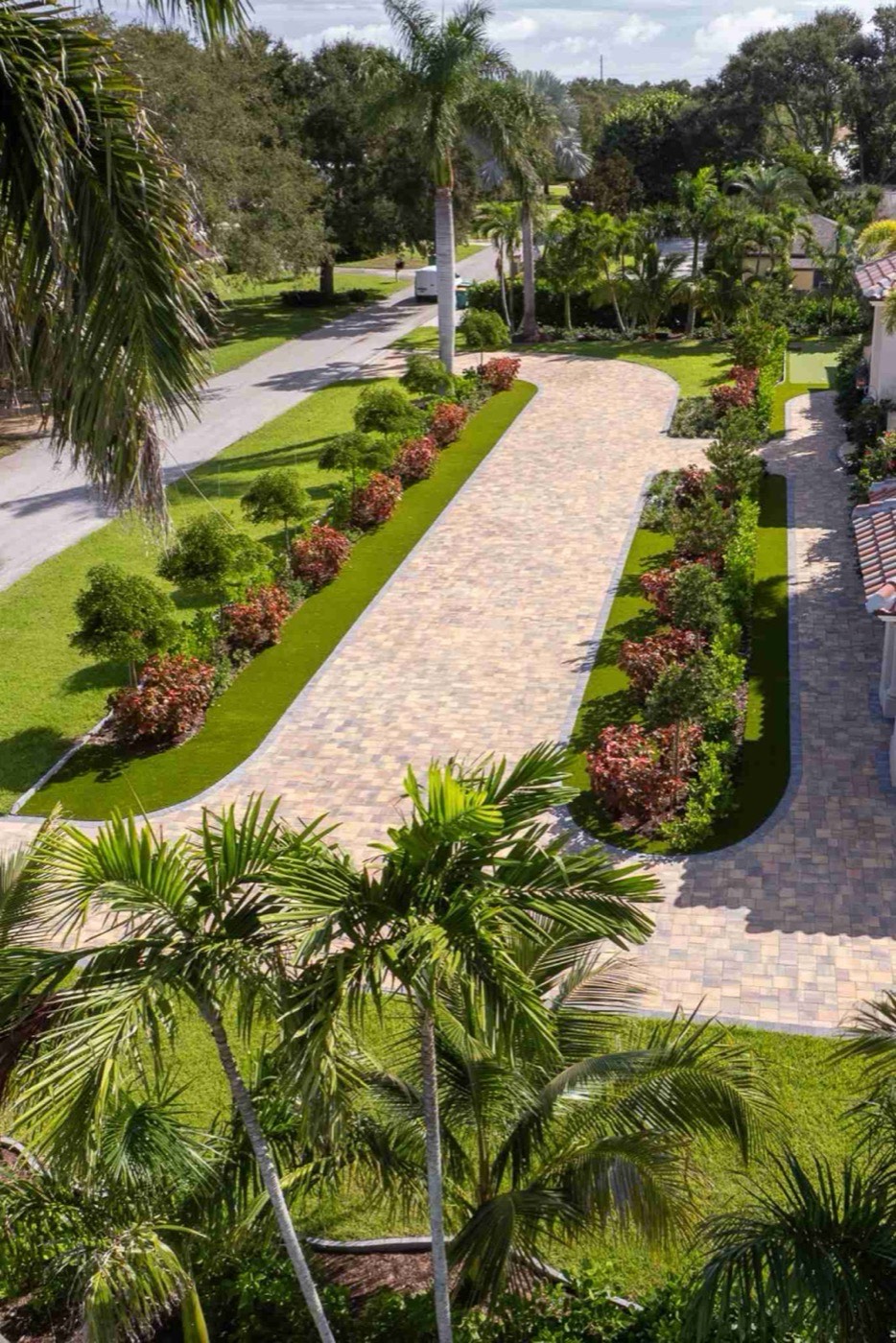 Aerial view of a curved paver driveway with landscaped center islands